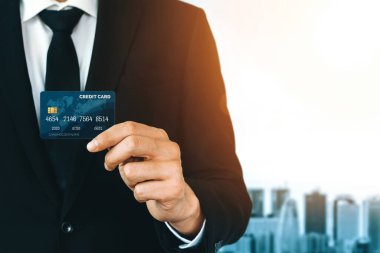 Bir kredi kartı tutan işadamının portresi kameraya ön görüntüyü yakından gösteriyor. Çevrimiçi alışveriş işi ve nakit ödeme konsepti. uds