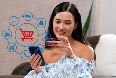Mavi elbise giyen şık bir müşteri çevrimiçi platform seçiyor. Akıllı tüketiciler, elektronik ticaret uygulamasını nakitsiz teknoloji alışveriş envanteri kullanarak izliyorlar. Siber Nakit.