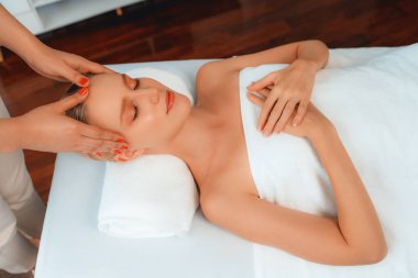 Kafkasyalı kadın stres önleyici kafa masajından ve lüks tatil beldesi ya da otel spa salonundaki modern ışık ortamında yüz güzelliği eğlencelerini şımartmaktan hoşlanıyor. Sessiz.