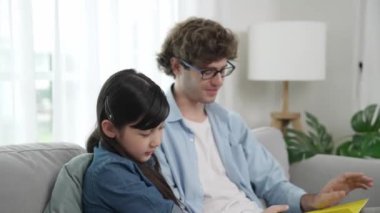 Beyaz bir baba ve tatlı bir kız kanepede otururken masal kitabı okuyorlar. Mutlu bir baba, sevimli bir Amerikan çocuğuna, birlikte zaman geçirirken hayal gücünün gelişmesi için hikaye anlatıyor. Pedagoji.