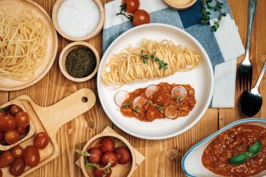 Lezzetli yiyecekler, ev yapımı spagetti, kıymalı domates sosu ve fesleğen fırlatma elementleri, şef masası dekoratif baharatlarla servis ediliyor. Varsayım.