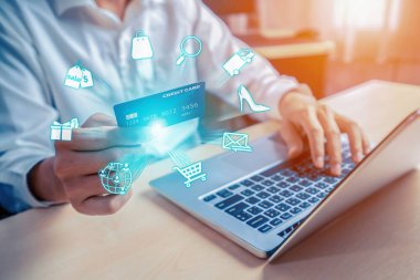 Beyaz tişörtlü, elinde kredi kartı olan şık bir müşteri çevrimiçi platform seçiyor. Açık e-ticaret uygulaması nakitsiz teknoloji alışveriş envanteri kullanırken akıllı tüketiciler dizüstü bilgisayar kullanıyor. Siber Nakit.