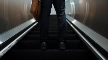 Yürüyen merdivenlerde duran zeki profesyonel iş adamının bacağı. Yetenekli proje yöneticisi terfi alıyor, yeteneğini arttırıyor, yükseltiyor, yeni bir pozisyon alıyor. Merkez. Bacağa odaklan. Sevinçli..
