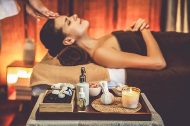 Aromaterapi masajı ambiyansı ya da spa salonu kompozisyon düzeneği bulanık kadınlara odaklı dekor mumları ve spa aksesuarları ile tatil köyü veya otel arka planında keyifli aroma spa masajı yapan. Sessiz.