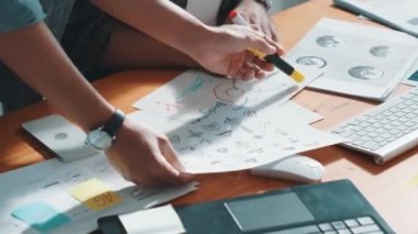 Takım ayakta dikilirken ve yorum yaparken müdürün fikir yazma konusunda üst düzey görüşü. Profesyonel tasarımcı logosu renk paletine bakarken ve renkli kalemle fikri kağıda yazarken. Sempozyum.