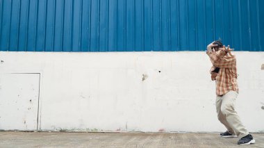 İspanyol komedi koreografı hip hop tarzında dans ediyor. Genç mutlu break dansçı B-boy dansı yapıyor. Sokak dansı yapan komik adamın hareket çekimi. Açık hava sporu 2024. Modern dans. ÇalışmaComment.