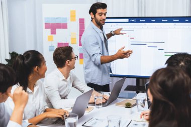 Proje yöneticisi monitörde proje yönetimi yazılım görüntülemesi, proje görevinin ilerlemesini izlemek ve toplantı masasında program planı yapmak suretiyle ekiple iletişim kurar ve işbirliği yapar. Tedbirli
