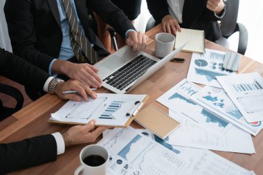 Ofis masasındaki finansal veri raporlarını analiz eden çeşitli bir grup iş analisti. Stratejik pazarlama planlaması için iş istihbarat analizine göre grafikler ve grafikler.