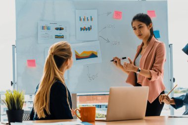 Çok kültürlü çalışma grubu. Farklı etnik kökenden iş kadınları, Kafkasyalı, Asyalı ve Araplardan oluşan bir ekip ofiste dizüstü bilgisayarla birlikte çalışıyor. Çok ırklı takım çalışması konsepti. uds