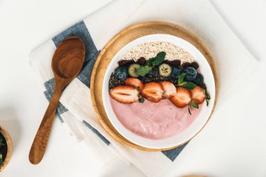Meyvelerin sunduğu yoğurt malzemelerini çilek, yulaf, kuru üzüm ve nane şekeriyle süslenmiş Chia tohumu ile beyaza boyarız. Pembe arka plan. Sağlıklı süt ürünleri seti. Bireysel.