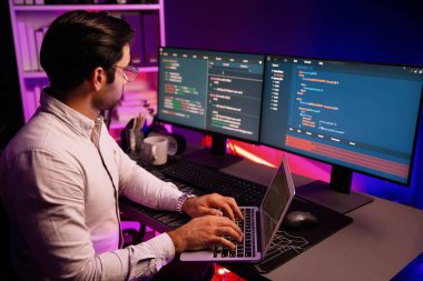 Akıllı IT geliştiricisi, yazılım kodlama sisteminde Neon Light ofis odasında yazı yazmak için çalışıyor, uygulama programı güncellemesi en son online web sitesi veritabanını çevrimiçi yapıyor. Tahmin et..