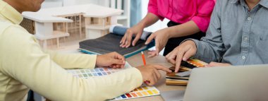 Yetenekli iç dizayn ekibi perde malzemelerini dikkatle seçerken iş arkadaşı da toplantı masasının üzerinde ev modeliyle perdenin rengini seçiyor. Yaratıcı tasarım konsepti. Değiştirilmiş.
