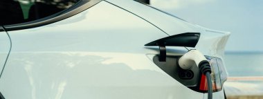 Açık hava EV şarj istasyonundaki elektrikli araba şarj istasyonu ya da deniz manzaralı araba, çevre dostu araba için alternatif ve sürdürülebilir enerji teknolojisi. Panorama Daimi