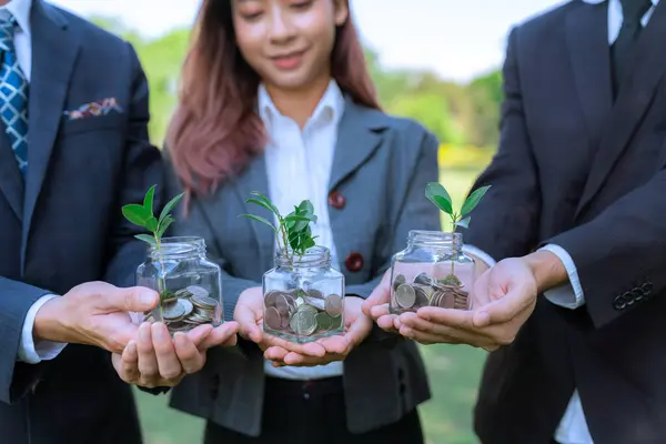 stock image Concept of sustainable money growth investment with glass jar filled with money savings coins with businesspeople as eco-friendly financial investment nurtured with nature and healthy retirement. Gyre