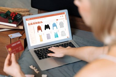 Genç bir kadın internet bankacılığı için kredi kartıyla dizüstü bilgisayar kullanıyor. Evinde online ödeme kapısı ile E ticareti yapıyor. Banka kartıyla modern ve kullanışlı online alışveriş. Blithe