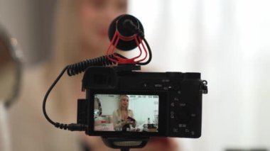 Güzellik ve kozmetik öğretim videosu içeriği yapan kamera görüntüsü kadını ya da perde arkası görüntüsü. Güzellik blogcusu izleyicilere ya da sosyal medya takipçilerine güzellik hizmetinin nasıl uygulanacağını gösteriyor. Blithe