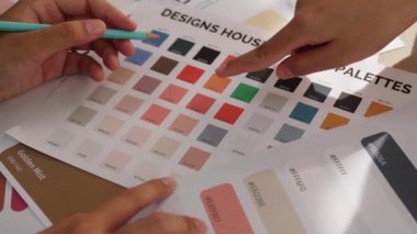 Grafik tasarımı için renk seçimi yapan ve beyin fırtınası yapan iki tasarımcının yavaş çekim çekimi ya da tasarım bürosunda kromatik danışmanlık hizmeti isteyen bir müşteri. Değiştirilmiş