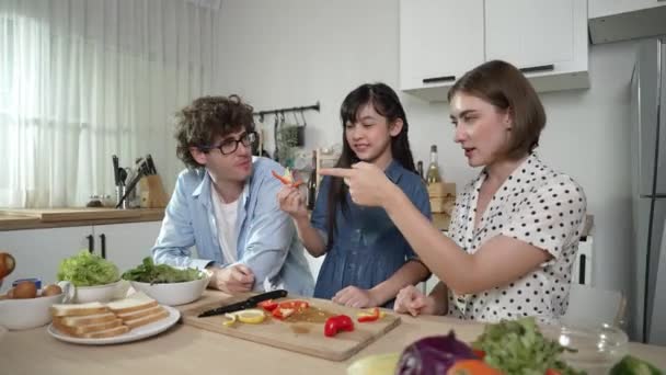 迷人的高加索父亲和母亲花时间在一起和亚洲女儿一起做新鲜的饭菜 爸爸和妈妈在厨房准备新鲜蔬菜做沙拉 吃蔬菜 教育学 — 图库视频影像