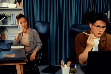 Stresli yüzü olan bir iş adamı dizüstü bilgisayarla e-posta beklerken aynı zamanda iş arkadaşı, modern ofiste gece yarısı danışmanlık işini tartışıyor ve şirket projesinde çalışıyor. İnfobahn.