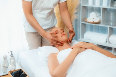 Kafkasyalı kadın stres önleyici kafa masajından ve lüks tatil beldesi ya da otel spa salonundaki modern ışık ortamında yüz güzelliği eğlencelerini şımartmaktan hoşlanıyor. Sessiz.