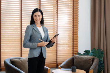 Psikiyatri ofisinde ya da terapi odasında koltukta oturan mutlu ve gülümseyen kadın psikolog portresi. Arkadaş canlısı ve profesyonel ruh sağlığı danışmanı ve terapisti. Blithe