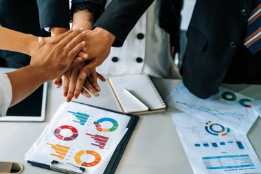 Birçok mutlu iş adamı neşe ve başarıyla el ele tutuşuyor. Şirket çalışanı başarılı bir iş projesini bitirdikten sonra kutlama yapıyor. Şirket ortaklığı ve başarı kavramı. uds