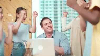 Kafkas öğretmeni ve çok kültürlü öğrenciler el çırpıyor ya da sınıfta masaya dizüstü bilgisayar ve teçhizatla başarılı bir proje için el ele tutuşuyorlar. Öğretim