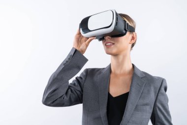 Yetenekli bir iş kadını arka planda dururken VR cam kullanarak görsel gerçeklik dünyasına bakıyor. Teknoloji yeniliklerini kullanarak metaevreni bağlamak için VR gözlüğü tutan akıllı bir yönetici. Kısıtlanma.
