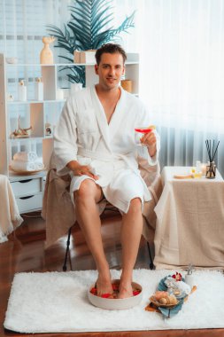 Güzellik ya da vücut bakımı güzellik salonu yaşam tarzı konsepti. Lüks otel kaplıcalarında ya da dinlenme odasında bornoz giyen bir adam. Tatil ve boş zaman rahatlığı. Sessiz.
