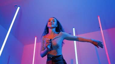 Latin dansçıların kameraya bakıp şehrin pop müziğiyle dans ettiği düşük açılı kamera. Profesyonel çekici hipster, mor veya neon ışıklı hip hop şarkısına geçiyor. Şık bir kumaş. Mutluluk.