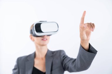 Profesyonel kadın lider programa dokunuyor ya da sanal gerçeklik gözlüğü kullanırken çalışıyor. Yetenekli iş kadını, görsel gerçeklik gözlüğü takarak metaevrene bağlanırken sistemi işaret ediyor. Kısıtlanma.