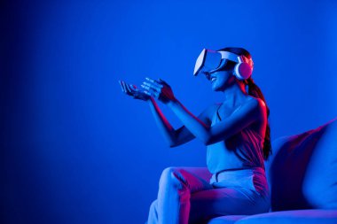 Kanepede oturan zeki kadın, neon ışıklı kulaklık takıyor metazik, fütüristik siber uzay topluluğu teknolojisini birbirine bağlıyor, elle sanal nesneyi izliyor ve onunla etkileşime geçiyor. Halüsinasyon.