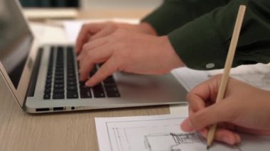 Mimari ve güvenlik mühendisi, modern ofiste doğruluk için mimari belge ve ölçüm aracına dizüstü bilgisayardaki inşaat ayrıntılı planlarını yazar. - Yakın çekim. Tanımlama.