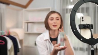 Kadın nüfuzlu kişi sosyal medya ya da blog için canlı yayın yapan video klip eleştirmeni Cilt Bakımı 'nı çekiyor. Kozmetik stüdyosu ışıklandırmalı mutlu genç kız çevrimiçi pazarlama oturumu yayını için..