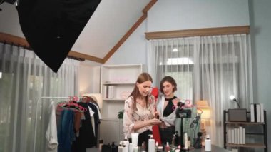 İki kadın nüfuzlu kişi canlı yayın yapan video klip eleştirisi kıyafetlerini sosyal medyada ya da blogda yayınlıyor. Stüdyo ışıklandırmalı mutlu genç kız çevrimiçi pazarlama oturumu yayını için..
