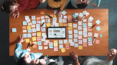 Başarılı bir projeyi kutlamak için el ele tutuşurken cep telefonu için tablet görüntüleme web sitesi prototipi üzerinde çalışan akıllı geliştiricinin üst görünümü. Takım el ele tutuşuyor. Sempozyum.