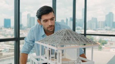 Modern ofiste gökdelen ve şehir manzaralı kalem ölçme modeli çatı uzunluğu kullanan profesyonel mimar mühendisi. Yetenekli proje yöneticisi ya da işadamı ev inşaatını kontrol ediyor. İzleme