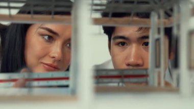 Ev modeli yapısını ölçmek için birlikte çalışan kooperatif mühendisi kapatın. Genç ve güzel mimar ev modelini ölçerken erkek mühendis performansını destekliyor. Tertemiz..