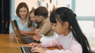 Dizüstü bilgisayarda çalışan ya da oyun oynayan bir grup çoklu etnik çocuk, programlama sistemi. Bilgisayarla komut ya da programlama sistemi yazarak çalışan neşeli, değişik öğrenci. Akıllı sınıf. Etkinlik.