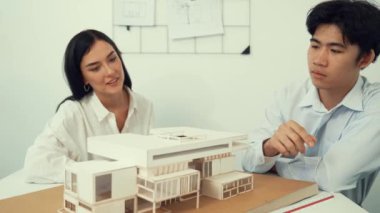 Profesyonel akıllı iş birliği mühendisi mühendis ekibi modern ofisteki ev yapısını planla kontrol ederken genç ve güzel proje yöneticisi not alıyor. Yaratıcı tasarım konsepti. Tertemiz...