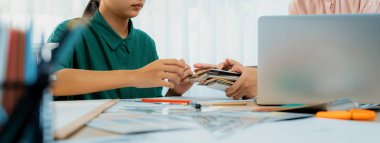 Akıllı iç dizayn ekibi proje için renk seçimini ev modelli renk örnekleri kullanarak ve renk örnekleri toplantı masasının etrafına dağılarak yapar. Yaratıcı tasarım konsepti. Değiştirilmiş.