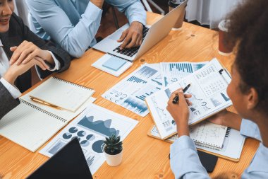 Çok ırklı analist ekibi toplantı masasındaki mali raporu analiz etmek için BI gösterge tablosunu kullanıyor. Çeşitli iş adamlarından oluşan bir grup, iş pazarlama kararı için FIntech 'in veri analizini kullanır. Uyum