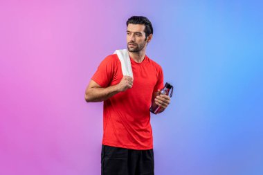 Vücut uzunluğunun tamamı atletik ve sportif delikanlıyı havluyla ve içme suyuyla izole edilmiş arka planda egzersiz yaparken çeker. Sağlıklı aktif ve vücut bakımı yaşam tarzı.