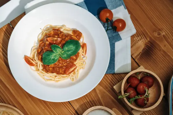 Presented health foods recipe special menu homemade cooking spaghetti with minced meat topped tomato sauce and basil shooting placing elements serving on white plate, side blow of radish. Postulate.