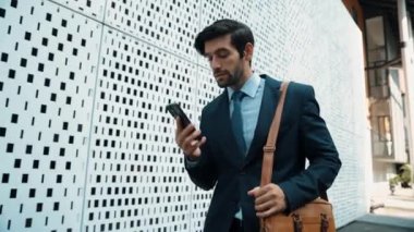 İş adamı telefona cevap verir ve iş yatırımları hakkında konuşur. İş planı, pazarlama stratejisi ya da çalışma hakkında konuşmak için akıllı telefonla konuşurken sokakta yürüyen mutlu bir yönetici. Sevinçli..