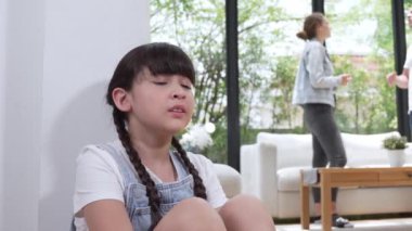 Stresli ve mutsuz genç kız köşeye kıvrılıp kulaklarını kapatarak arka planda ebeveyninin tartışmasını engelliyor. Evde aile içi şiddet ve travmatik çocukluk depresyona dönüşür. Titiz