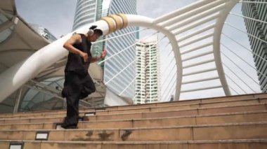 Asyalı hippi kulaklık takar hip hop dinler ve müziğe yönelirdi. Profesyonel break dansçı ya da alçak açılı kamerayla dans ederken merdivenlerden yukarı çık. Açık hava sporu 2024. Yumuşak bir şekilde..