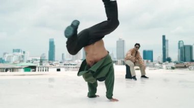 Profesyonel break dans takımı çatıda çok kültürlü arkadaşlar varken break dans alıştırması yapıyor. Genç modern dans grubu hip hop hareketi yapıyor. Tarz, moda, aksiyon. Açık hava sporu 2024 hiphop..