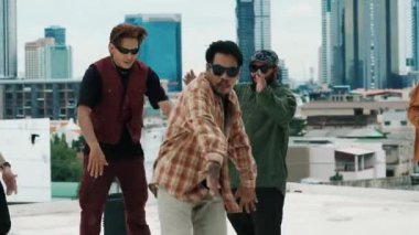 Çatıda çok kültürlü arkadaşlar varken profesyonel İspanyol break dansçısı B boy dansı. Genç modern dans grubu hip hop hareketi yapıyor. Tarz, moda, aksiyon. Açık hava sporu 2024 hiphop..