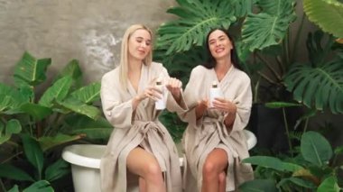 Modern otelde küveti olan tropikal ve egzotik bir spa bahçesi mi yoksa elinde bornozla gezen iki kadın mı yeşil yapraklı, boş zamanların tadını çıkarıyor? Blithe